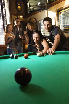 Young caucasian woman receiving advice on shooting pool ball while playing billiards.