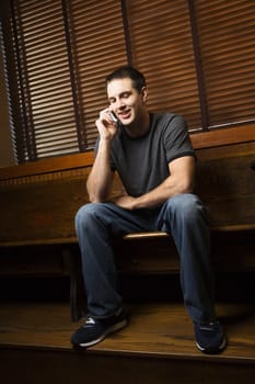 Young man talking on cellphone while hanging out at pub.