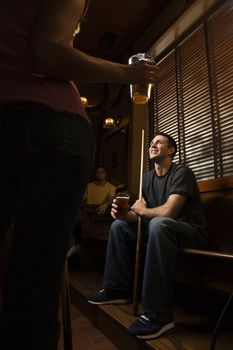Young man holding billiards cue while hanging out at pub.