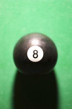 Close-up of eight ball on green billiards table.