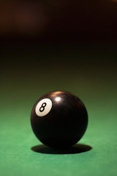 Eight ball on green billiards table.