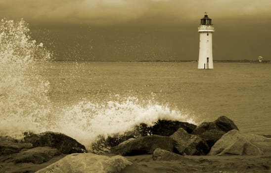 Old dissused lighthouse on a stormy day in sepia