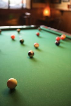 Woman's hand preparing to hit pool ball while playing billiards.