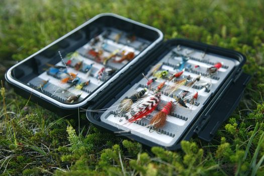 Flyfishing box full of colorful flies - short depth of field