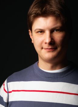 Close-up of a young man smiling and looking at camera