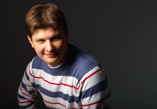 Close-up of a young man smiling and looking at camera