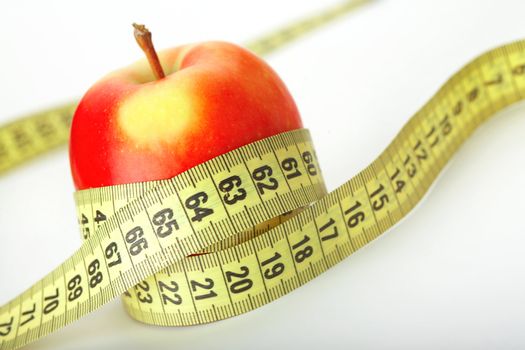 Red apple with a measuring tape on white