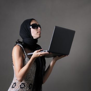 Portrait of classy woman with sunglasses holding laptop