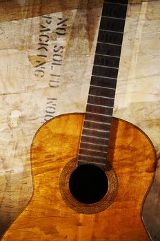 Old acoustic guitar against grunge aged surface