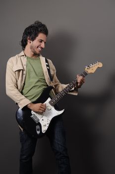 Portrait of young handsome musician playing electric guitar