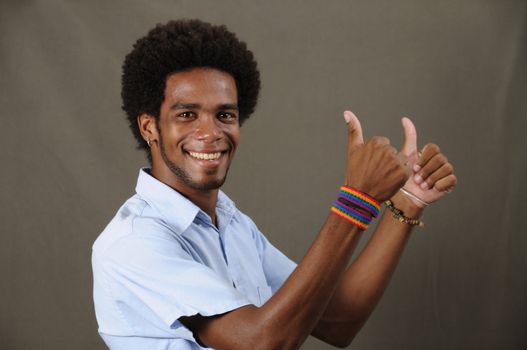 Portrait of joung friendly african american man with thumbs up