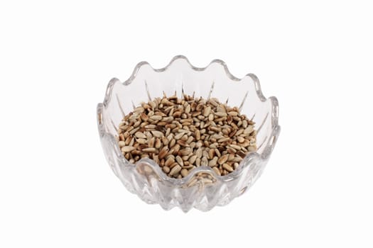 Roasted sunflower seeds in glass bowl, isolated on white