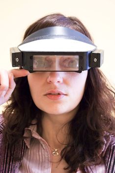 young woman looking through magnifying glasses