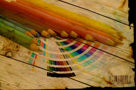 Multicolor drawing pencils and color guide over grunge abstract background