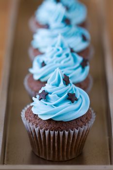 Row of miniature chocolate cupcakes decorated with stars