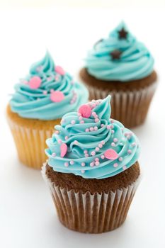 Trio of blue cupcakes against white