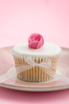 Cupcake decorated with a pink wafer rose