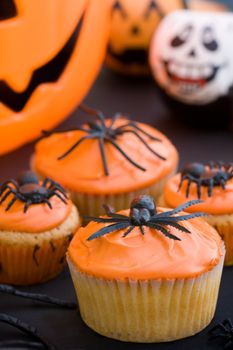 Cupcakes decorated with orange frosting and spiders