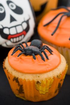 Cupcakes decorated with orange frosting and spiders