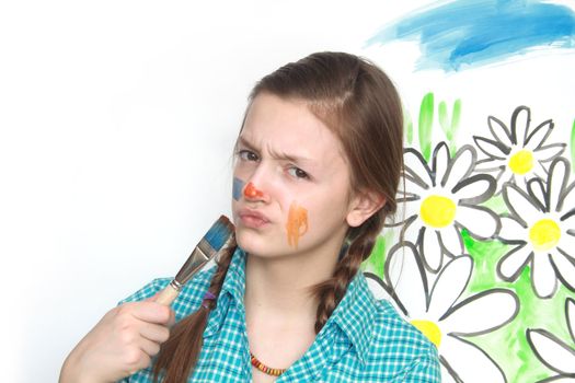 Young nice girl with brush on background with painted flowers