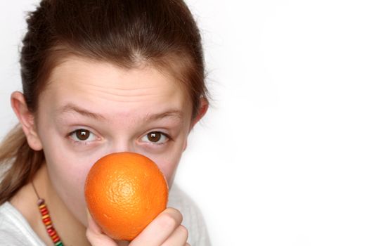 Closeup portrait of nice young girl holding orange on white background with copy space