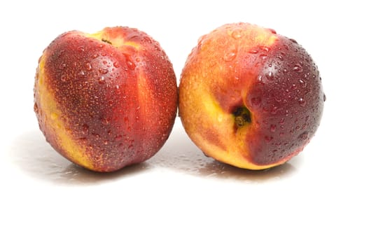 close-up on two fresh organic nectarines, isolated on white