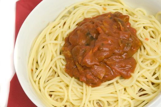 close-up on a full bowl of pasta with meat, vegetables, sauce, spices and cheese