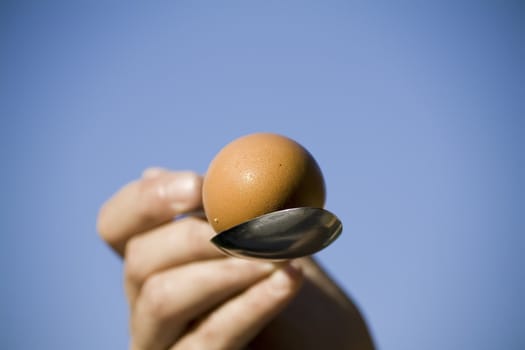 hand holding an egg in spoon