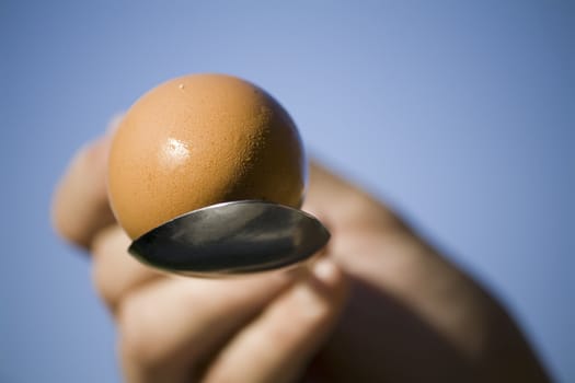 hand holding an egg in spoon