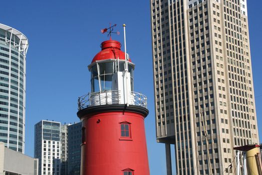 Traditional harbour lighthouse with backdrop of modern highrise in Rotterdam, Holland.