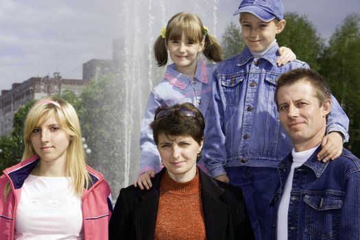 Family against a fountain and the sky with clouds