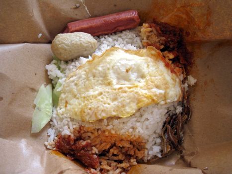 this is a delicious coconut rice, malaysian style breakfast, rice with spicy sauce, fried egg, fried anchovies