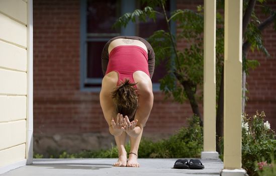 Pretty Young Woman doing Yoga on a Porch