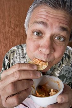 Close Up of a Man Eating Chip Dip from a Bowl