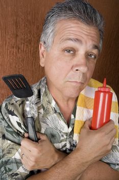 Latin American Man with Barbecue Implements and a Ketchup Bottle