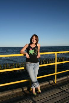 young woman resting on the pier, smile