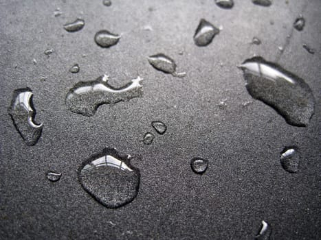 close up for a few water drops on a metallic surface