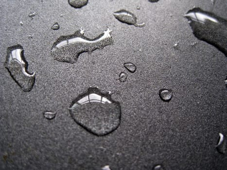 close up for a few water drops on a metallic surface