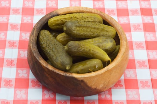 a bowlful of preserved garnish on a table cowered with checkered buckram