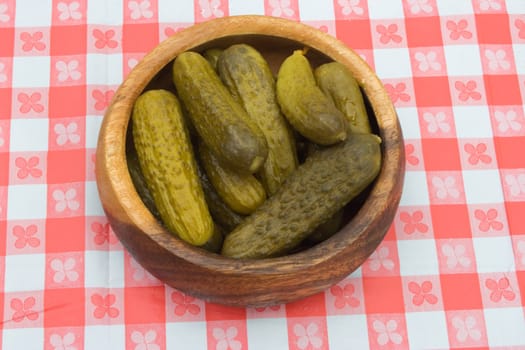 a bowlful of preserved garnish on a table cowered with checkered buckram