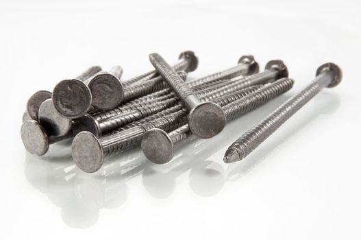 Close up of a small pile of steel nails isolated over white.