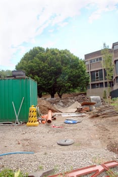 A photograph of a building site strewn with tools, materials and warning signs