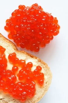 Closeup of a whole lot of red caviar near white bread and butter