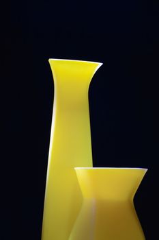 Closeup of nice modern yellow vases isolated on black background