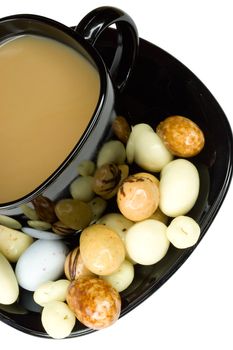 close-up black cup of coffee with milk and candies, isolated on white