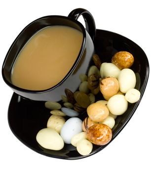 close-up cup of coffee with milk and candies, isolated on white