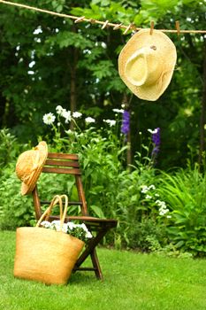 Straw hat hanging on clothesline in the garden
