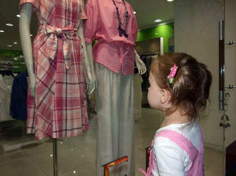 Little girl is dreaming about the beautiful dress