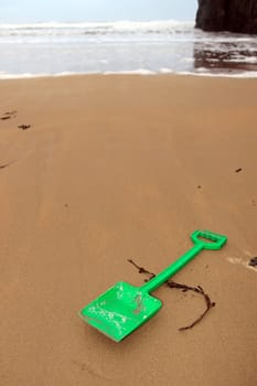 green plastic spade abandoned lying on a beach in ireland