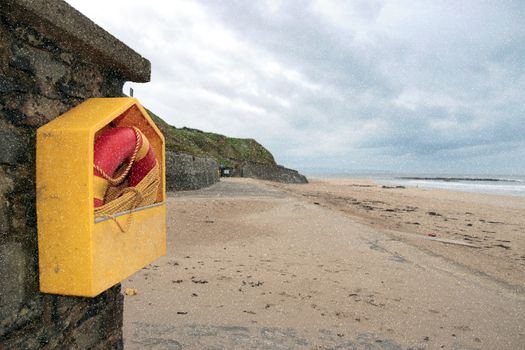 a rescue buoy at ballybunion beach in ireland on a cold snowy deserted winters day